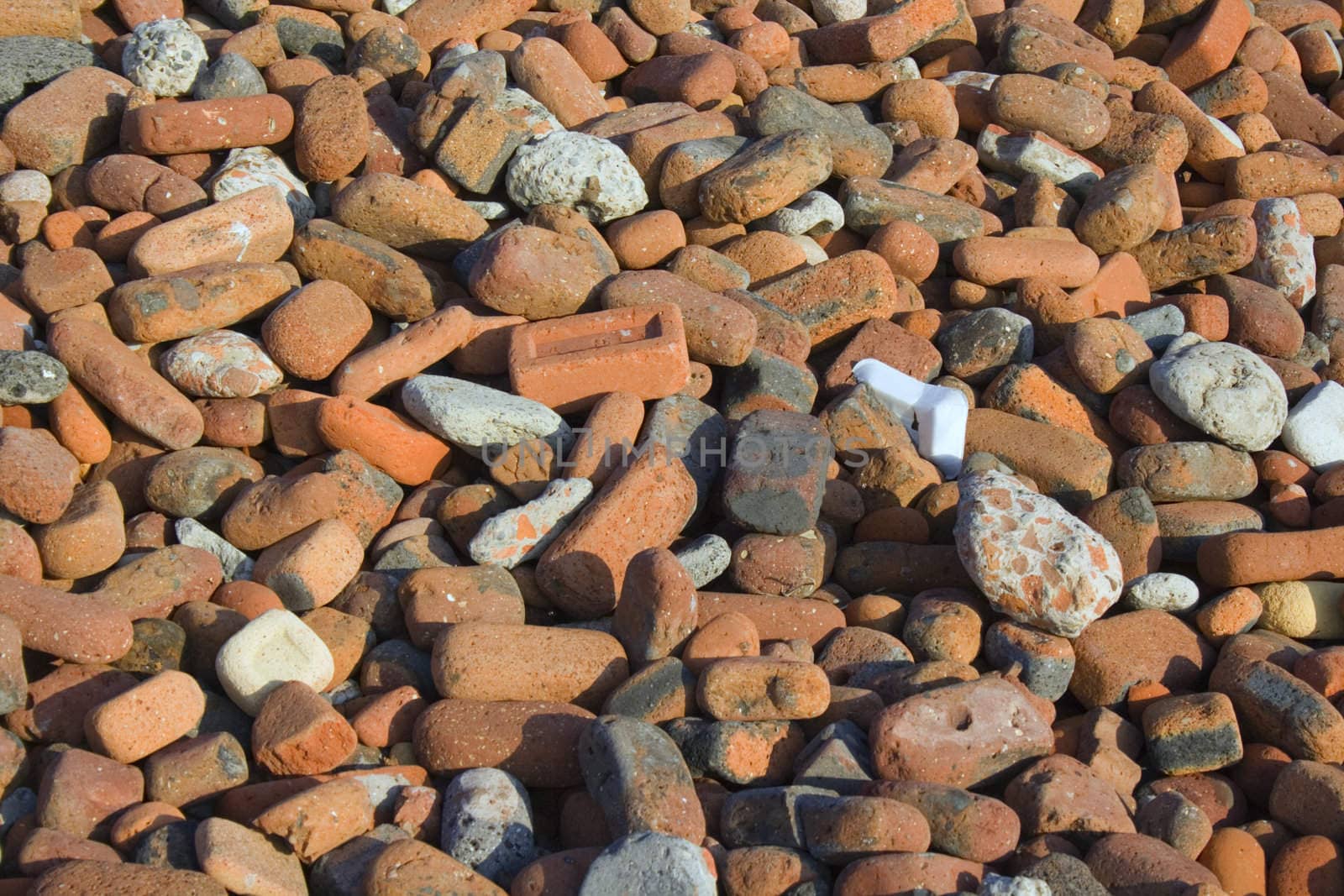 Pile of bricks rounded and weathered by the incoming tide