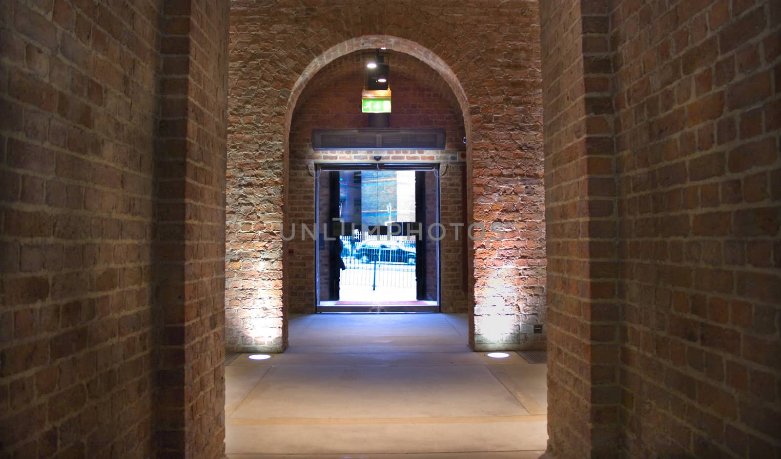 Looking through ancient arch towards modern glass exit door
