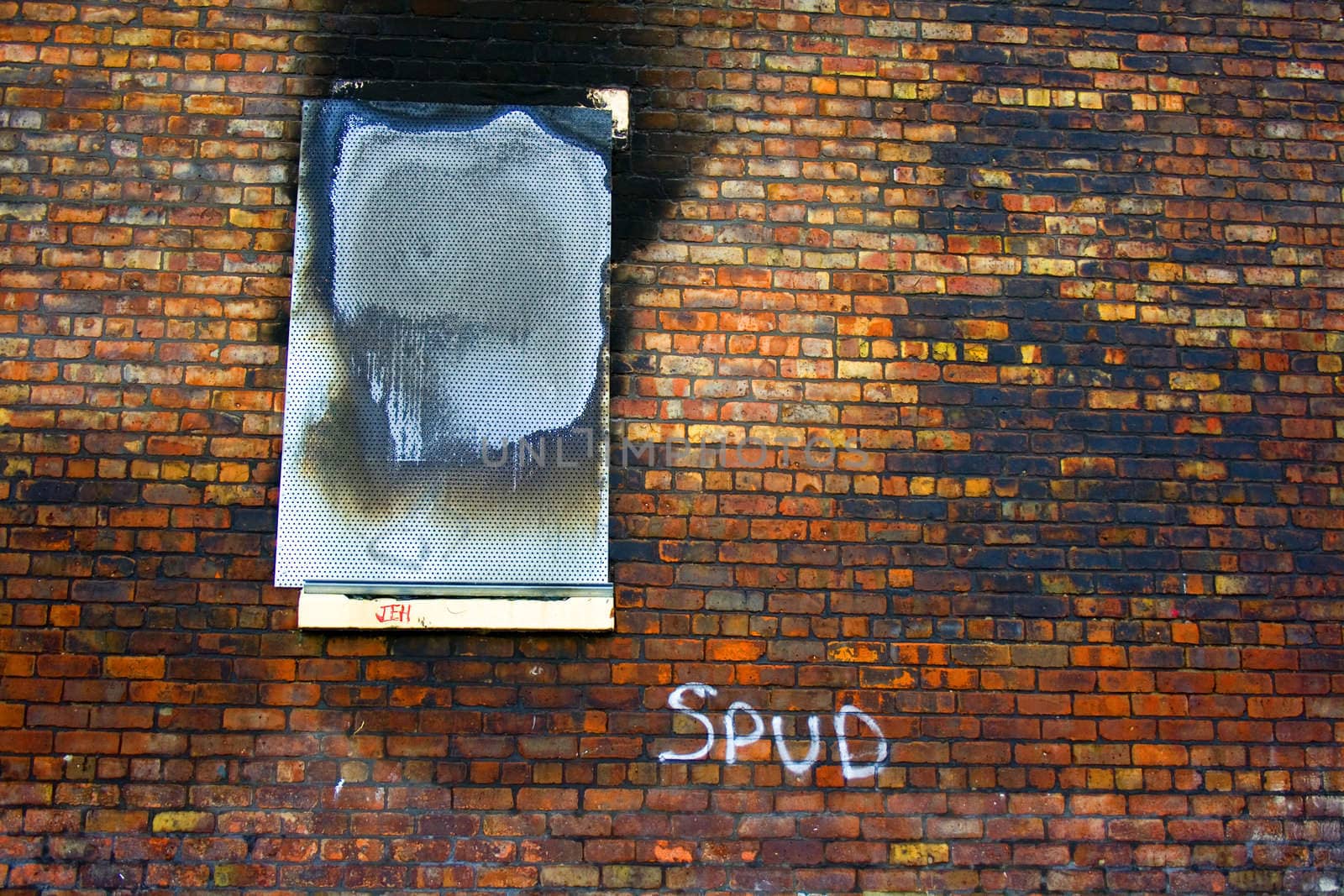 Old wall with burnt out boarded up window