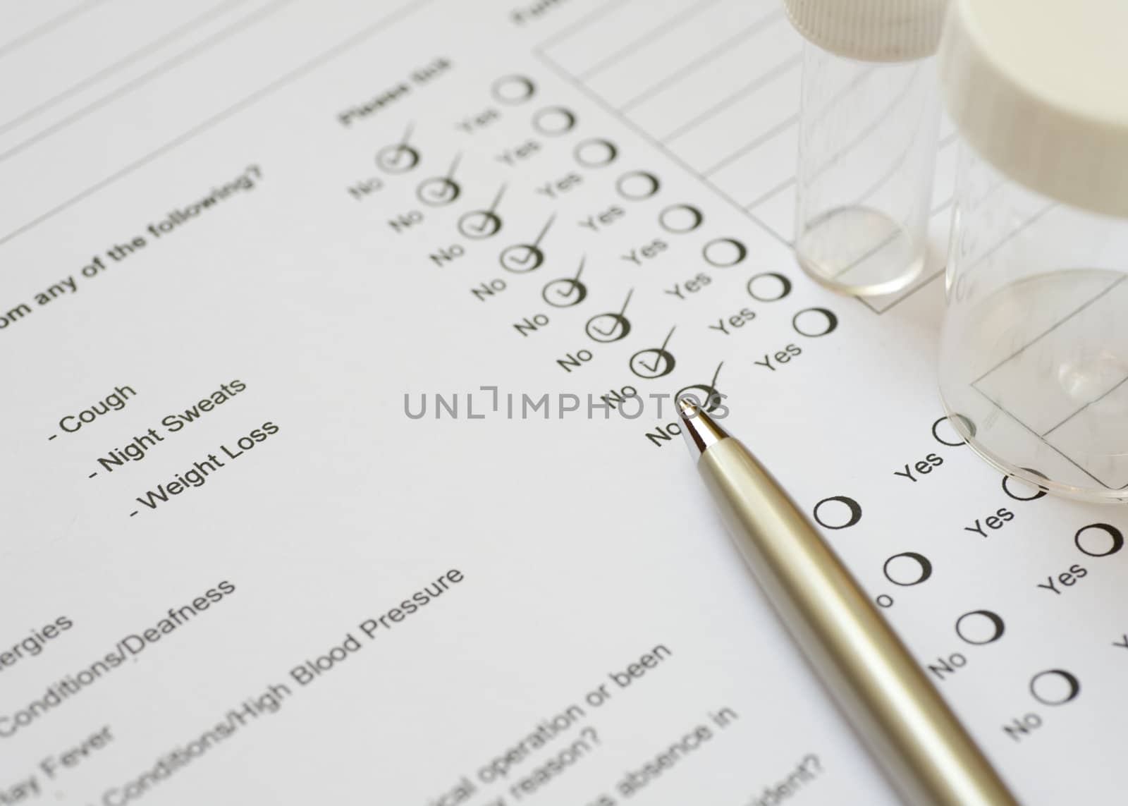 Health questionnaire with pen and specimen containers.