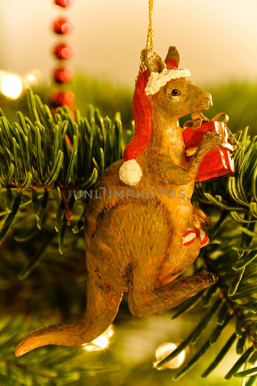 Christmas Tree Decoration - Australian Kangaroo with presents and Santa Claus�s hat, hanging in Tree with lights and other decoration visible