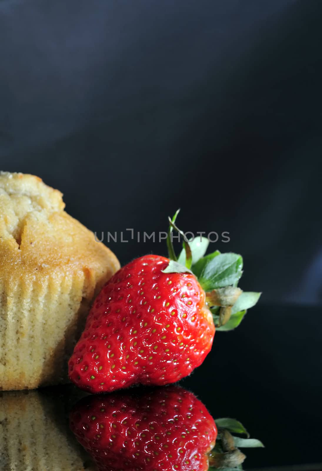 close up on freshly baked berry muffin and fresh strawberry