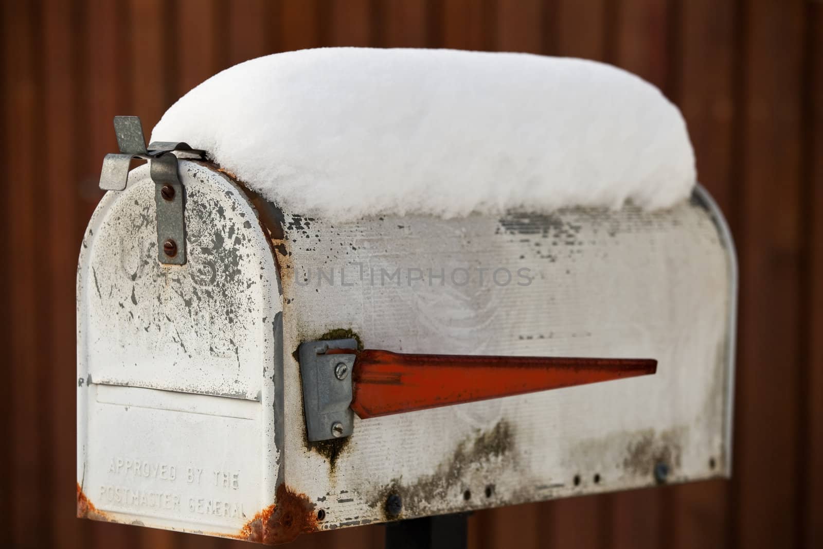 fresh snow on a battered mailbox