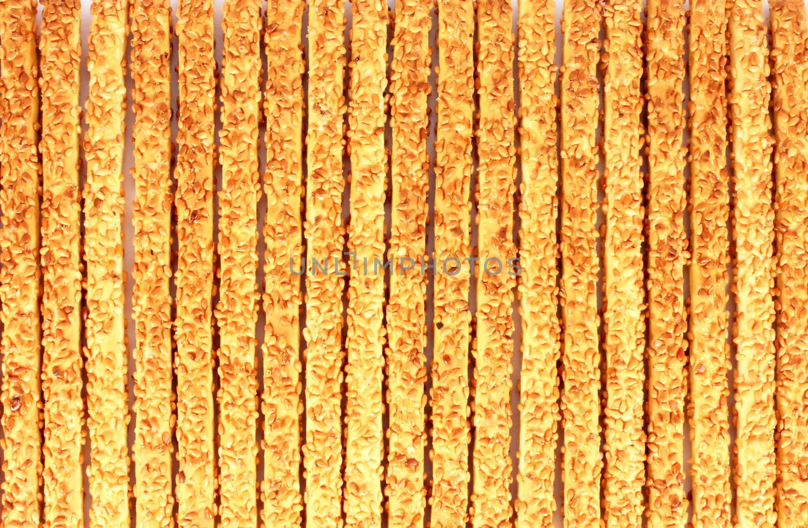 Many breadsticks with sesame seeds background