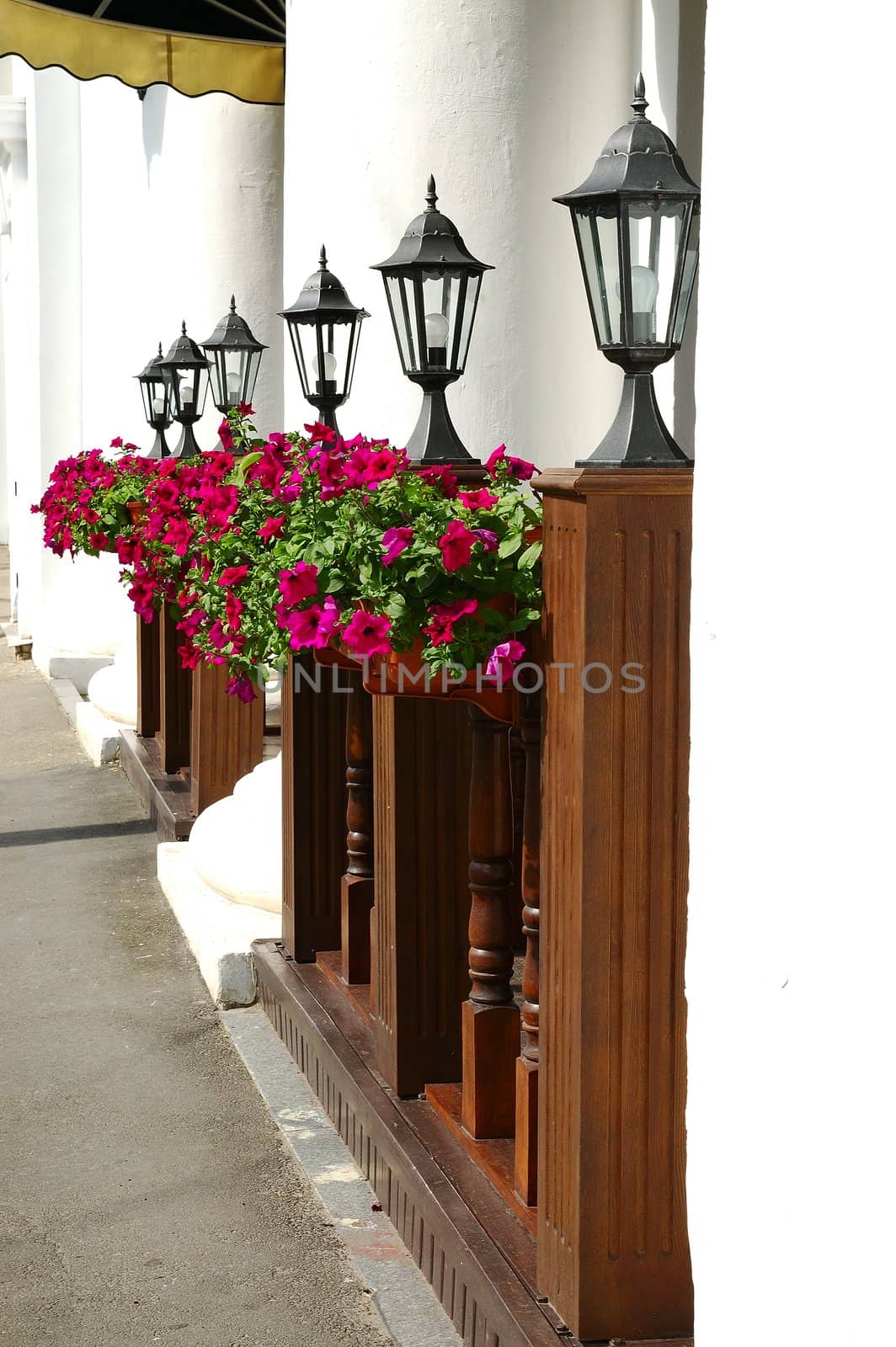 Row of black street lamps against the white columns