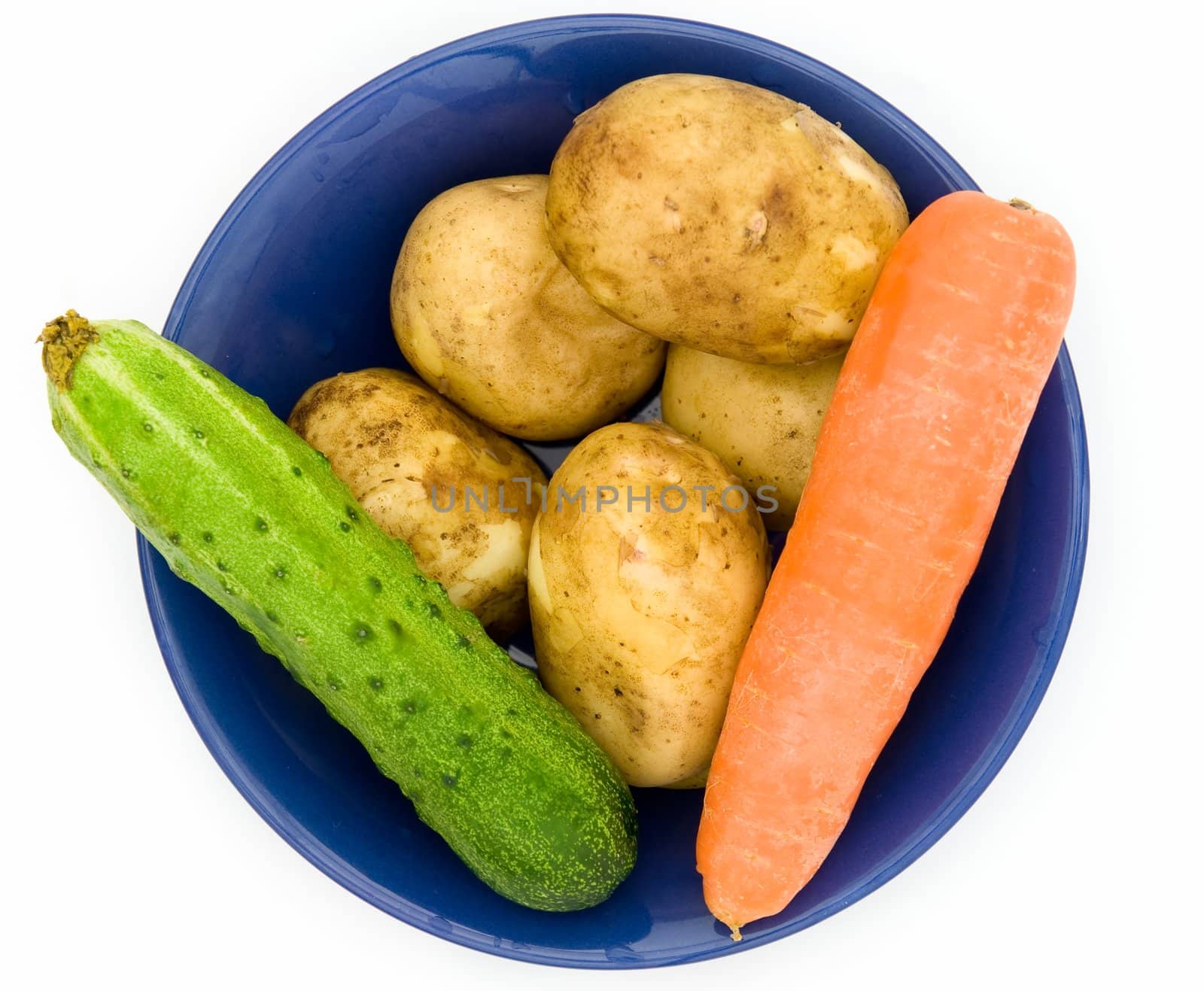 Potatoes, cucumber, carrots. Plate with vegetables on a white background.