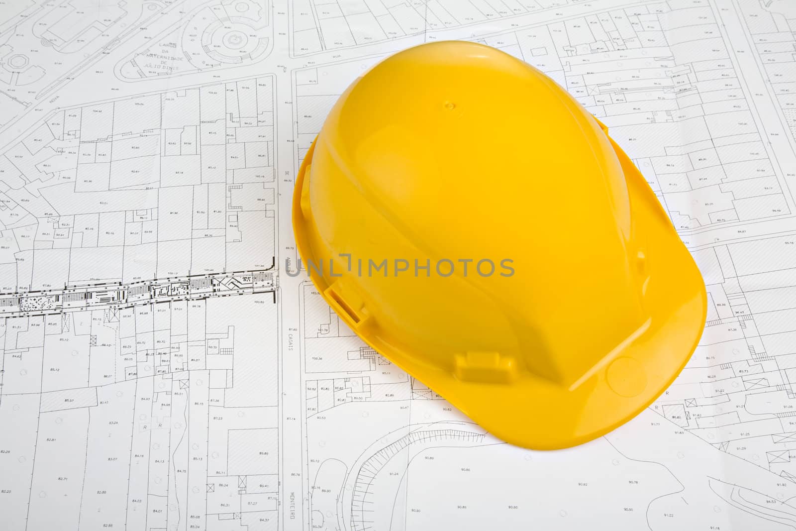 A yellow protection hat over a blueprint sheet.