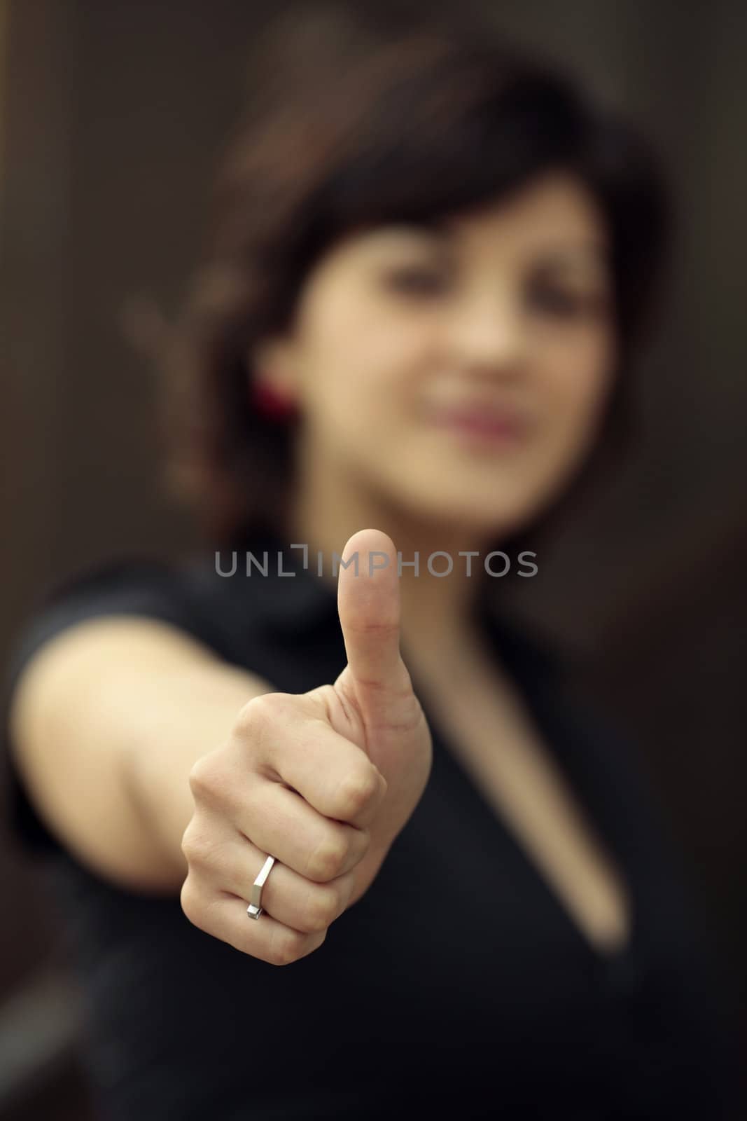 young lady making the OK sign and only the hand is in focus 