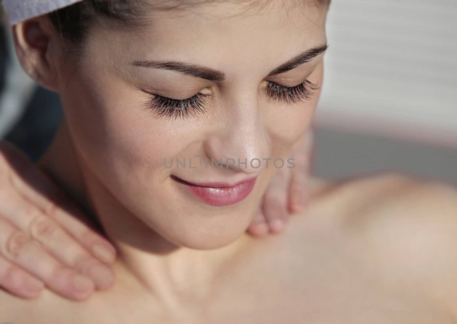 close up of a young attractive lady with her eyes closed having a relaxing massage at an outdoor beauty center