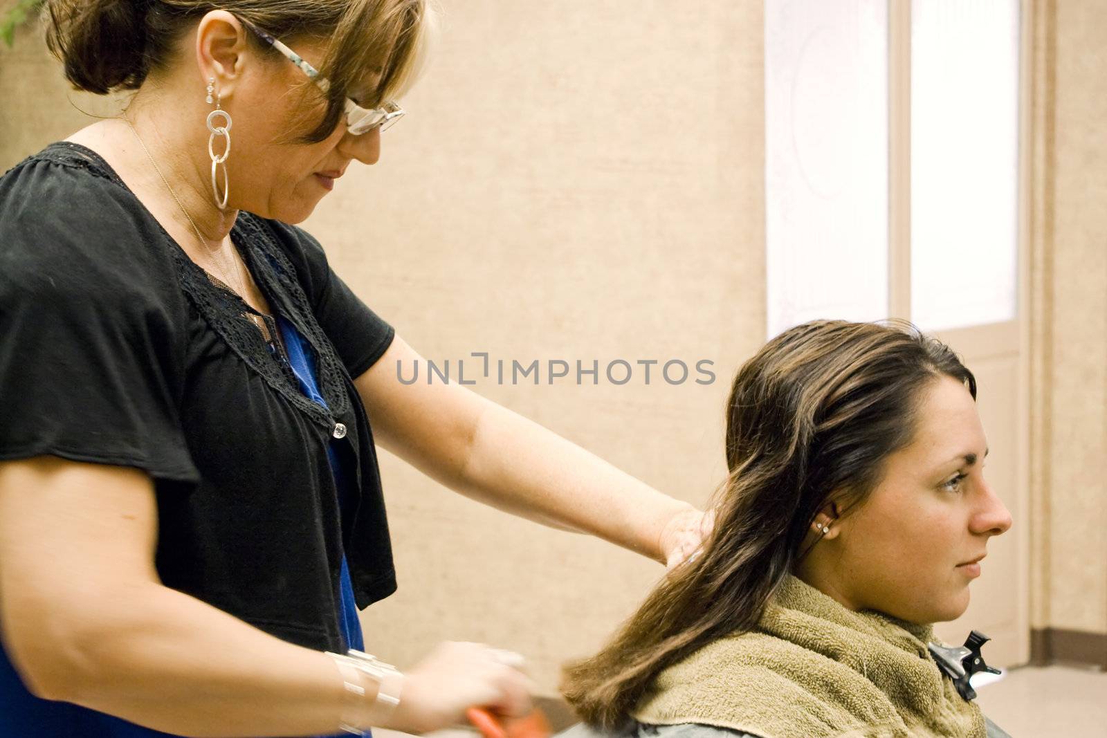 A hairdresser working on a clients hair at the salon.