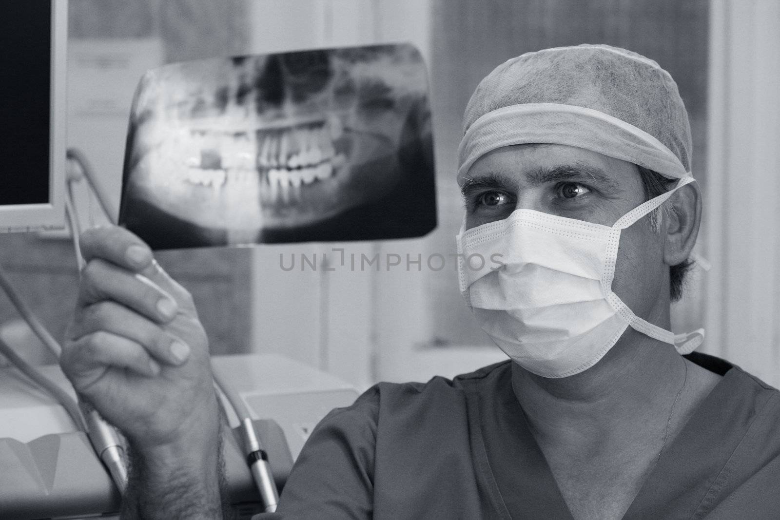 The doctor closely studying x-ray of human teeth
