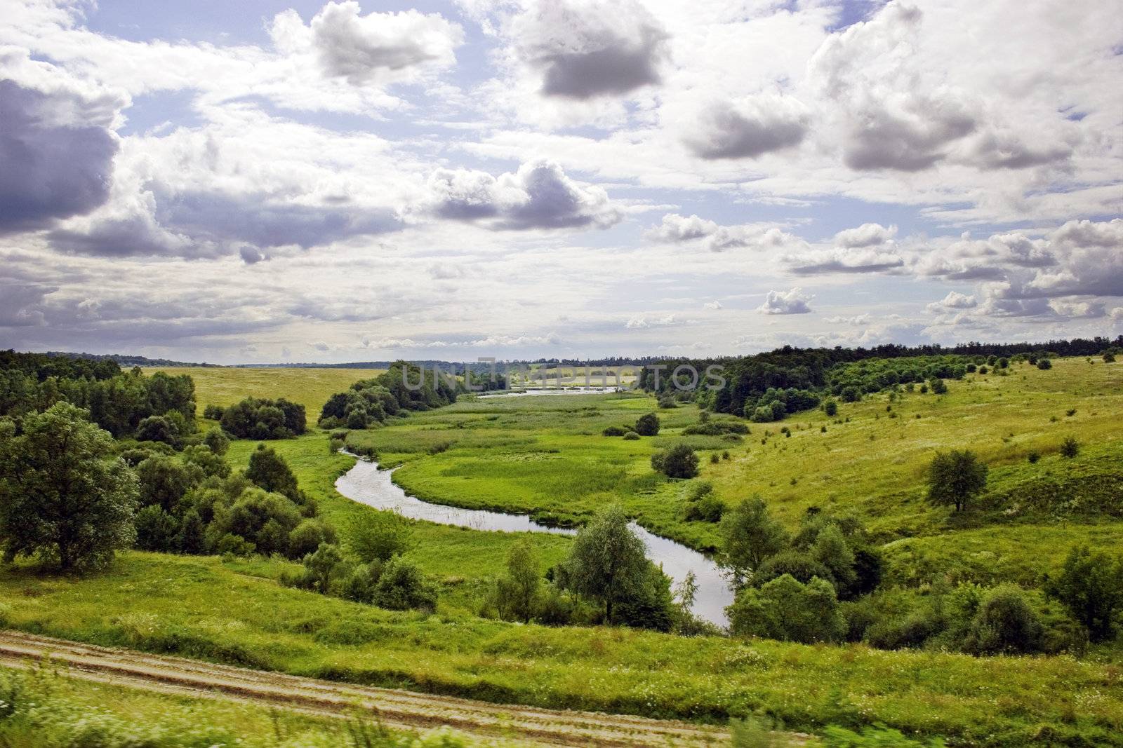River and meadows with trees and blue sky with clouds. Summer's landscape. Russia.