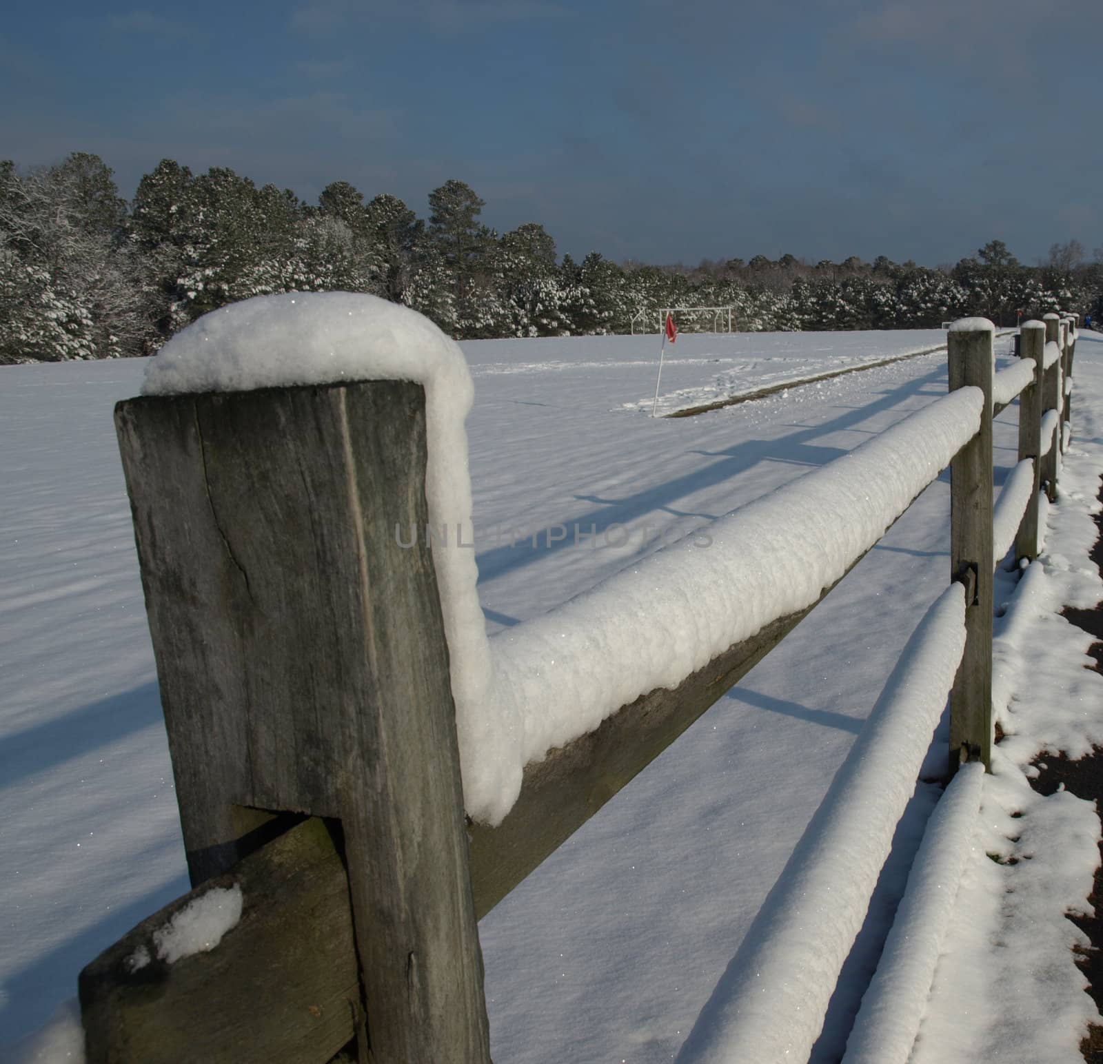 A fence along a field in the snow