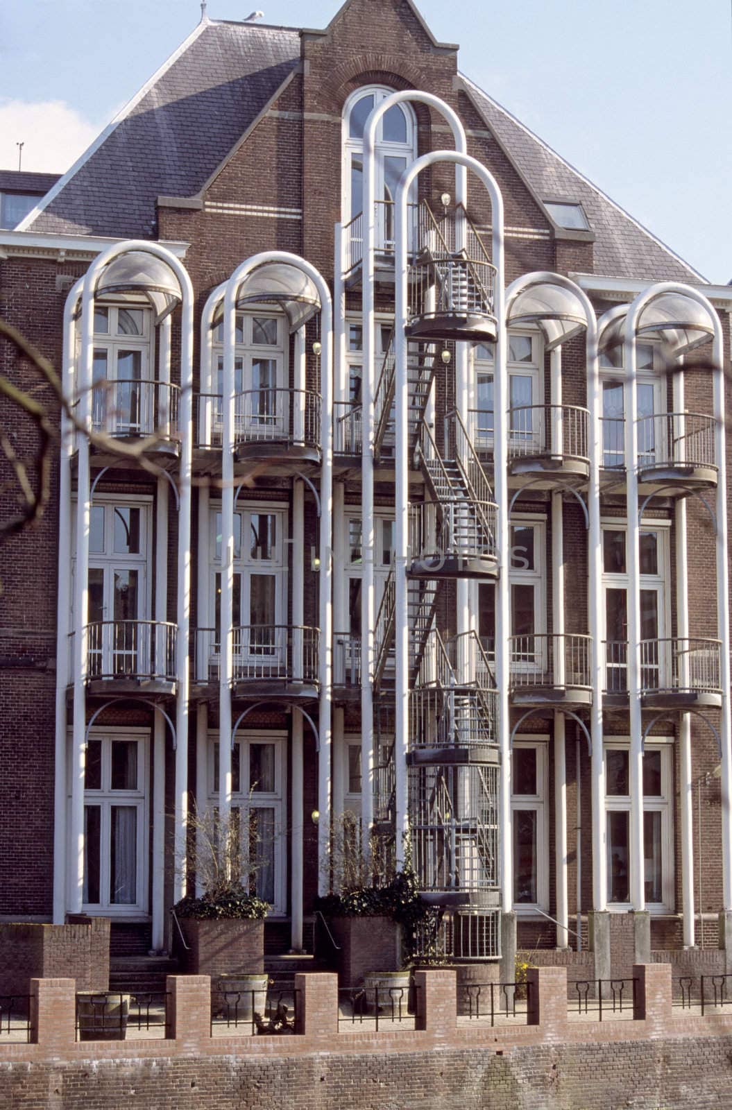 A traditional canal house is modernised with elaborate ballconies and a fire escape that echos the arches of the windows.