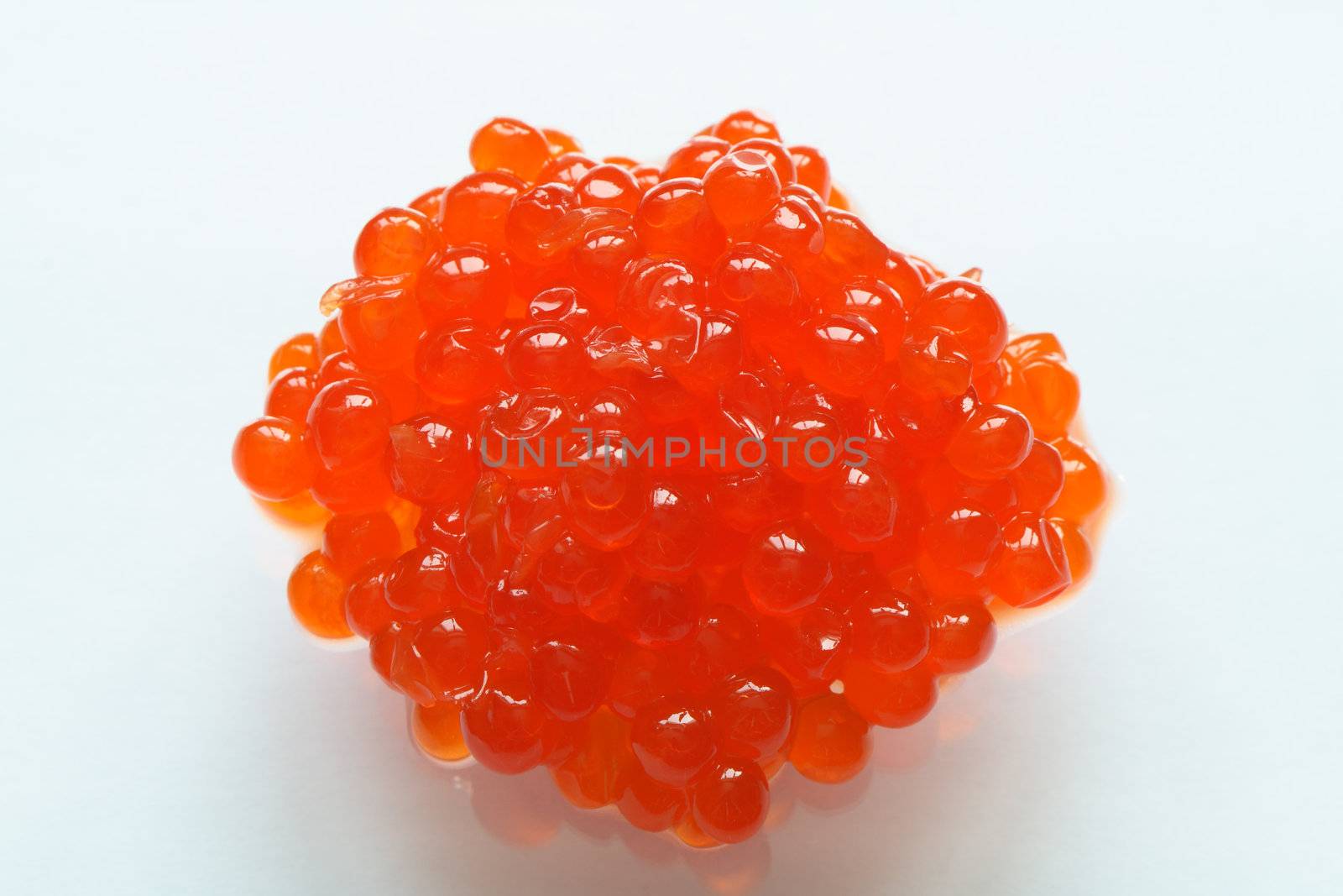 A whole lot of red caviar with reverberation on white background