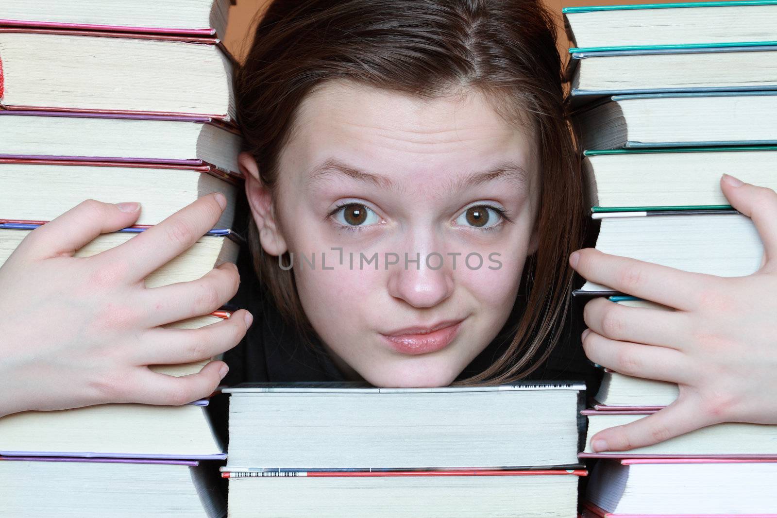 Portrait of nice young girl inside stacks of books