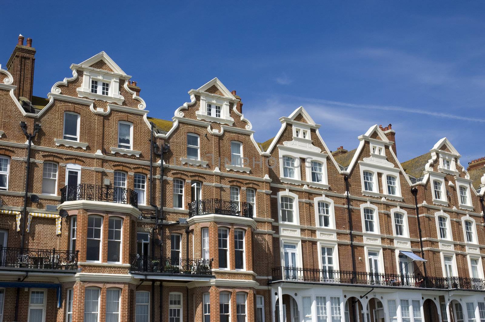 A row of victorian townhouses with a blue sky