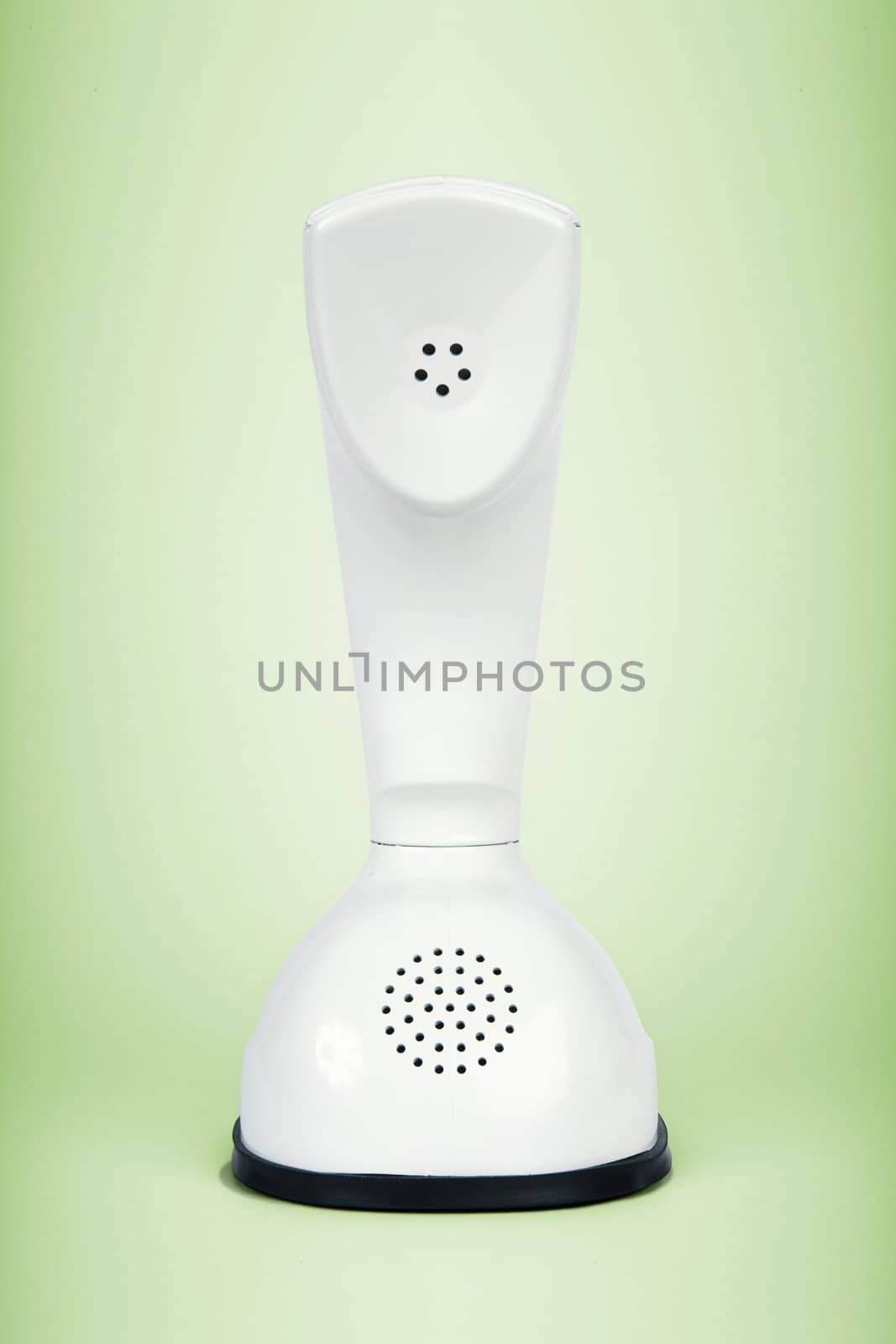 Stylish retro telephone from the sixties isolated on green background