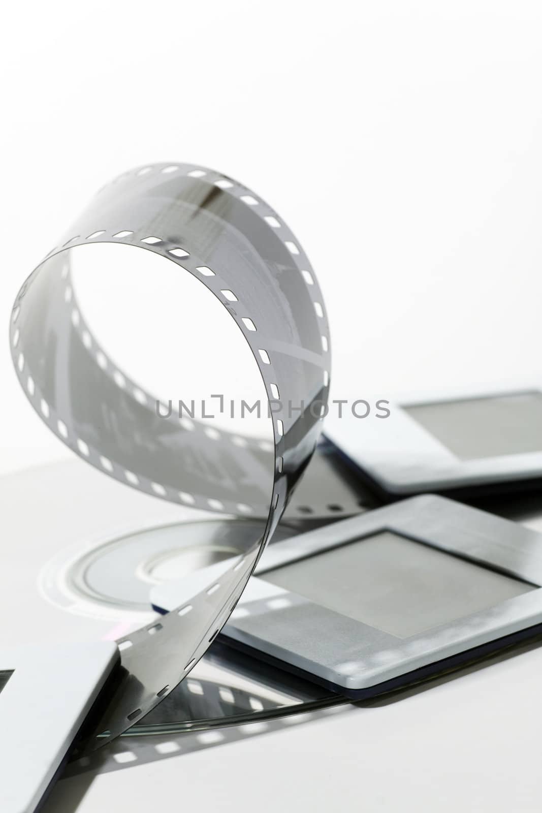 black and white negative film strip, cd and dia on white background