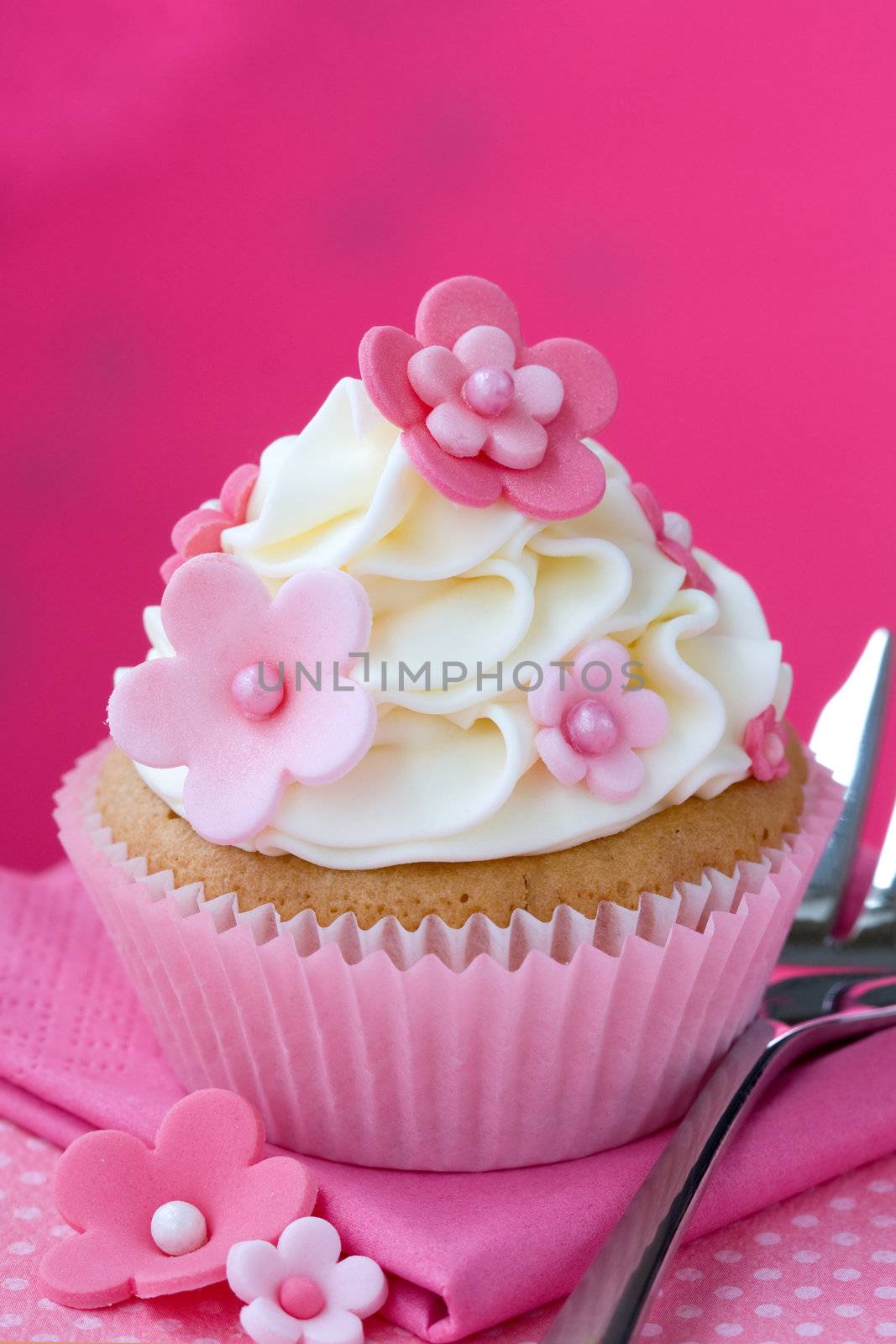 Cupcake decorated with pink fondant flowers
