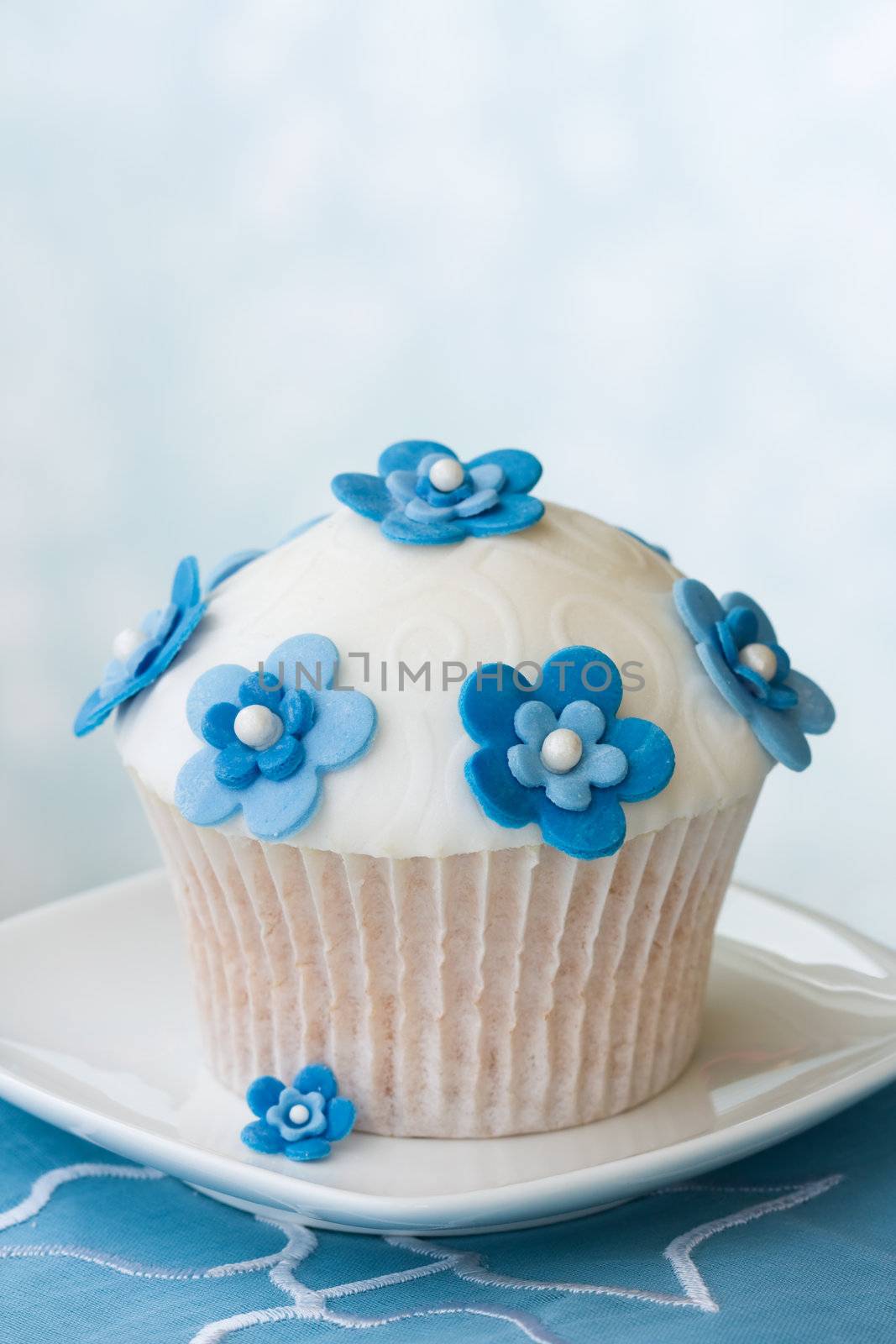 Cupcake decorated with blue fondant flowers