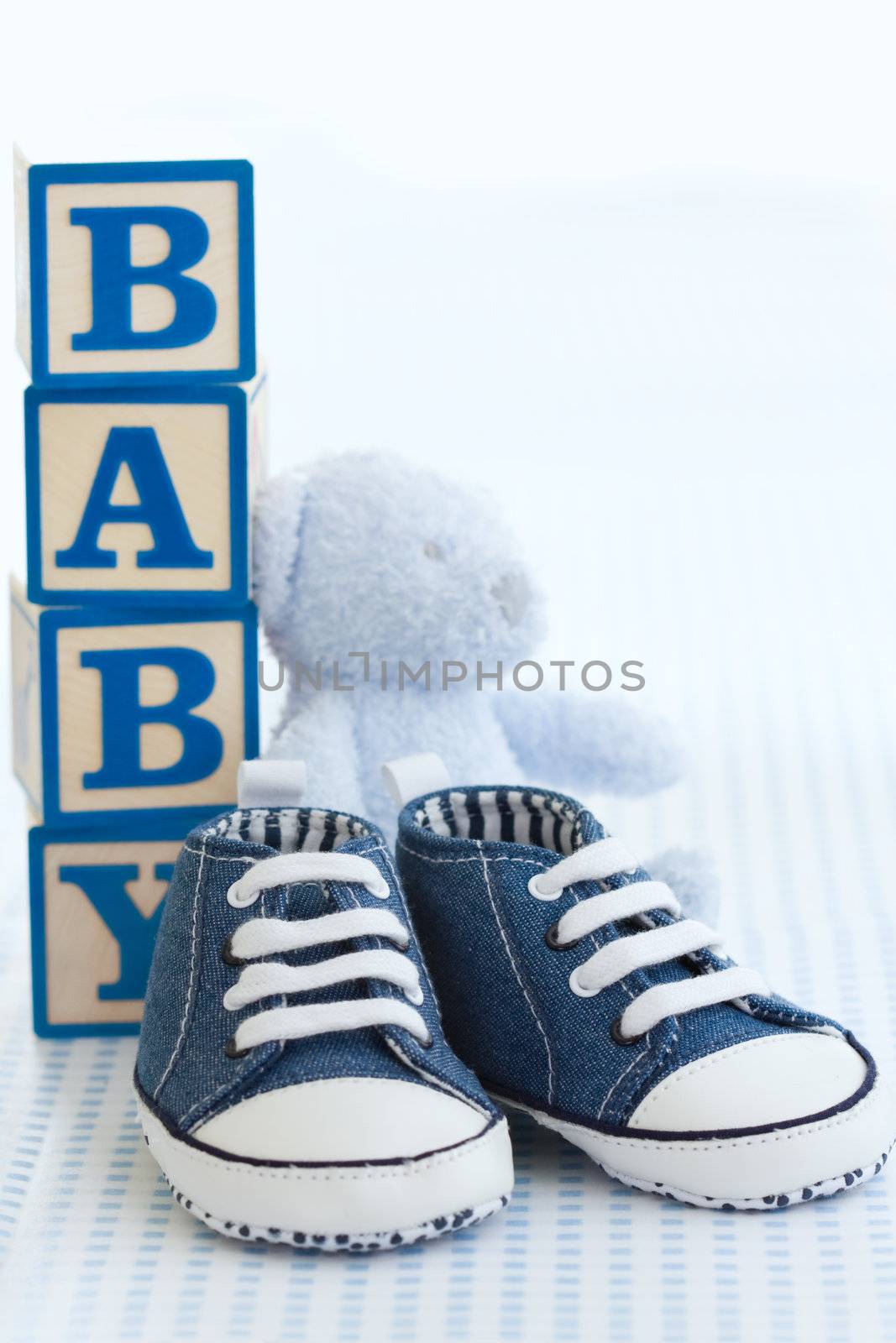Blue denim baby shoes, baby blocks and teddy bear