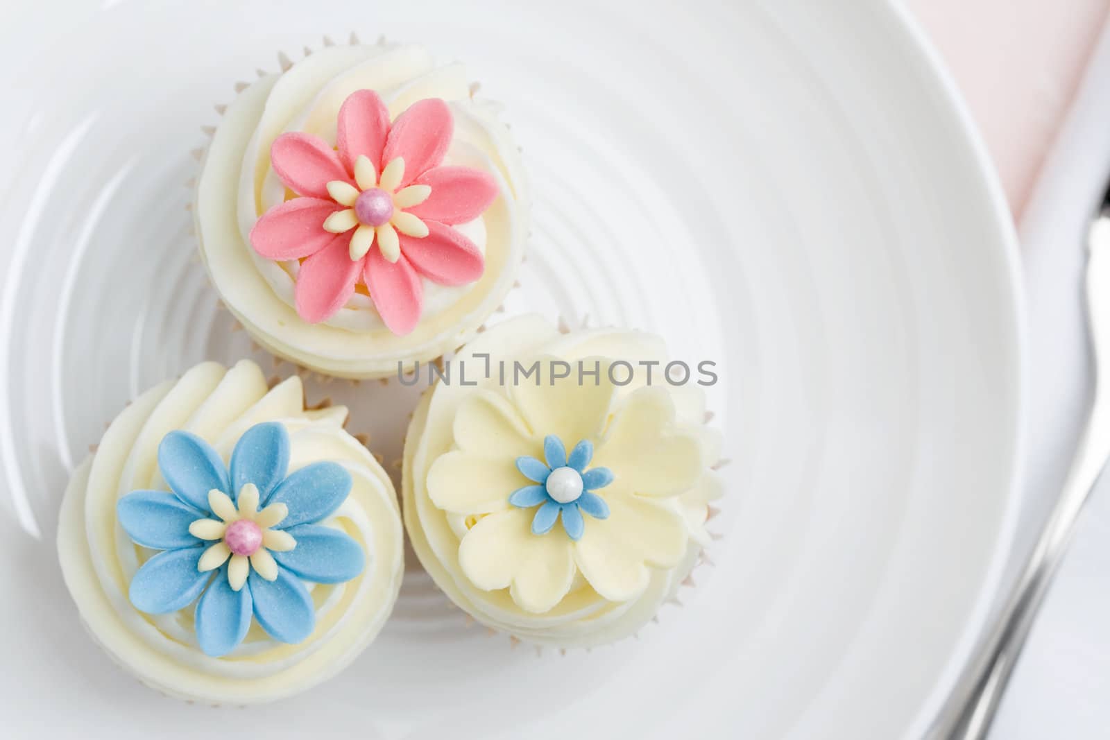 Three flower cupcakes on a white plate