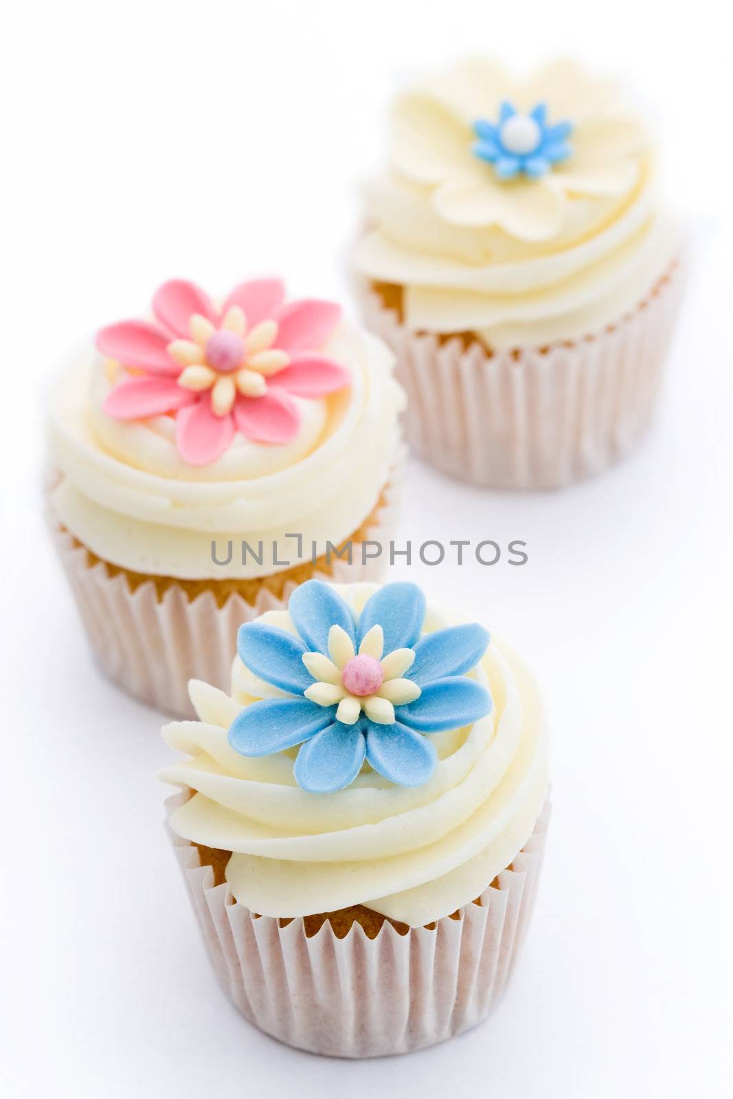 Three flower cupcakes isolated against white