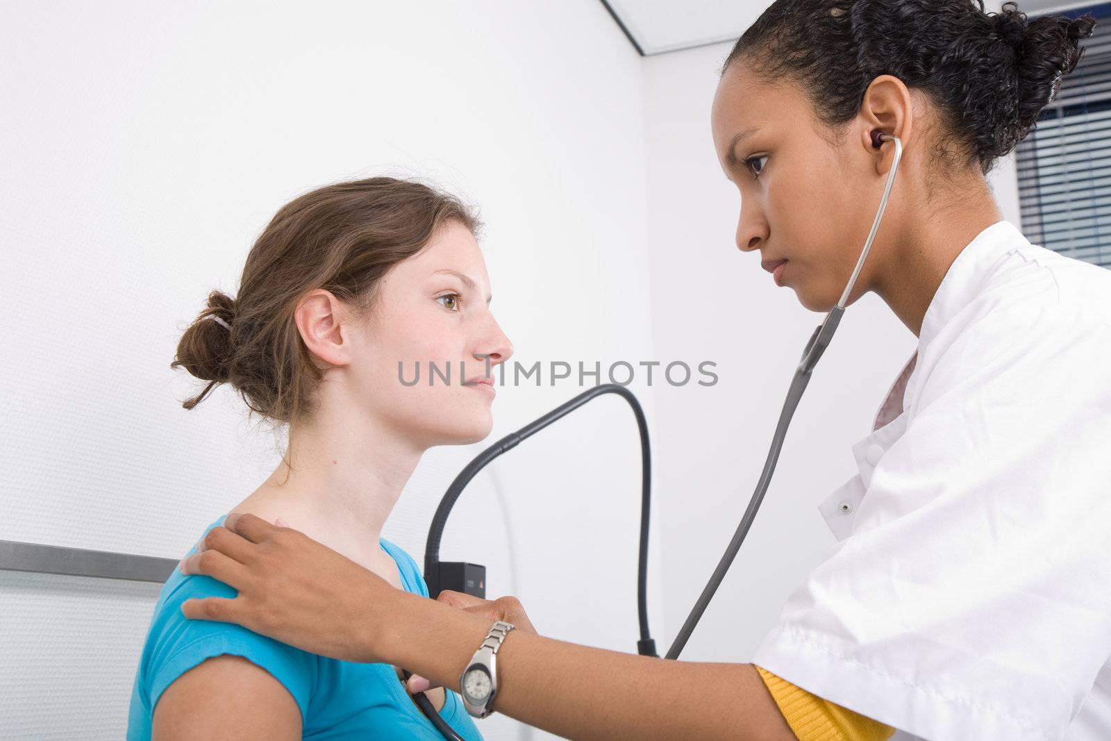 Doctor listening to the heartbeat of her patient with a stethoscope