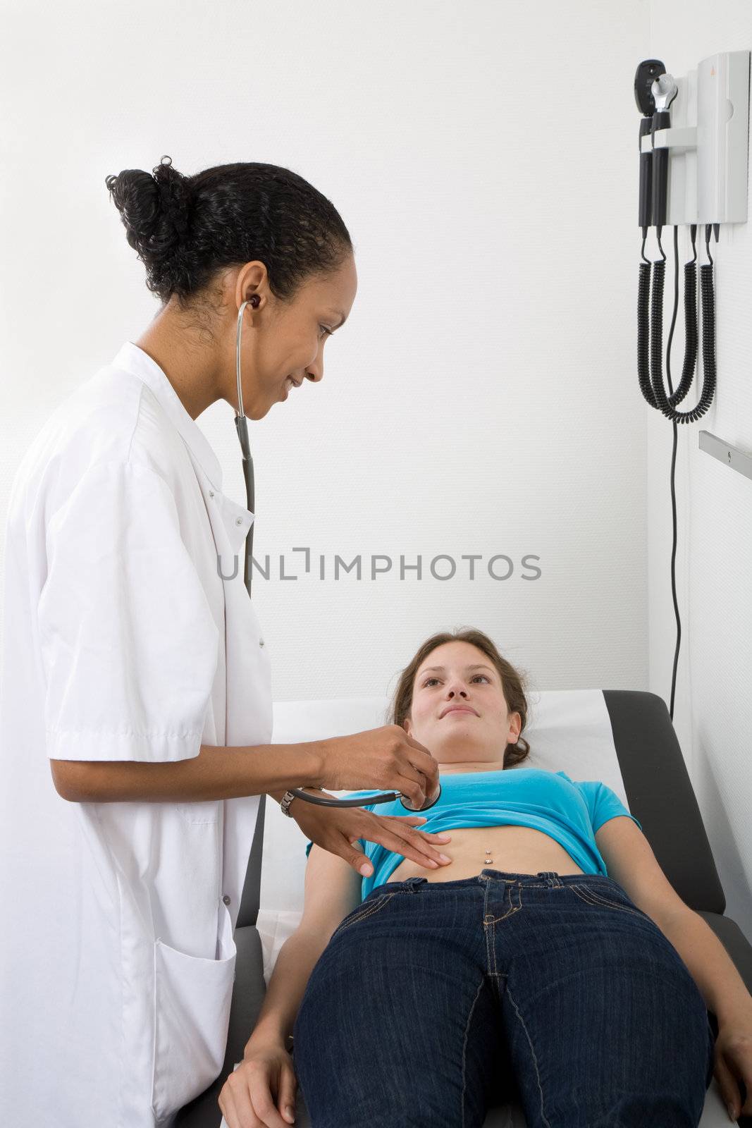 Doctor checking the abdomen of one of her patients
