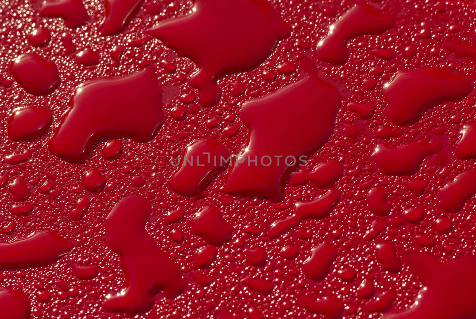 Raindrops on a red surface. A close up.