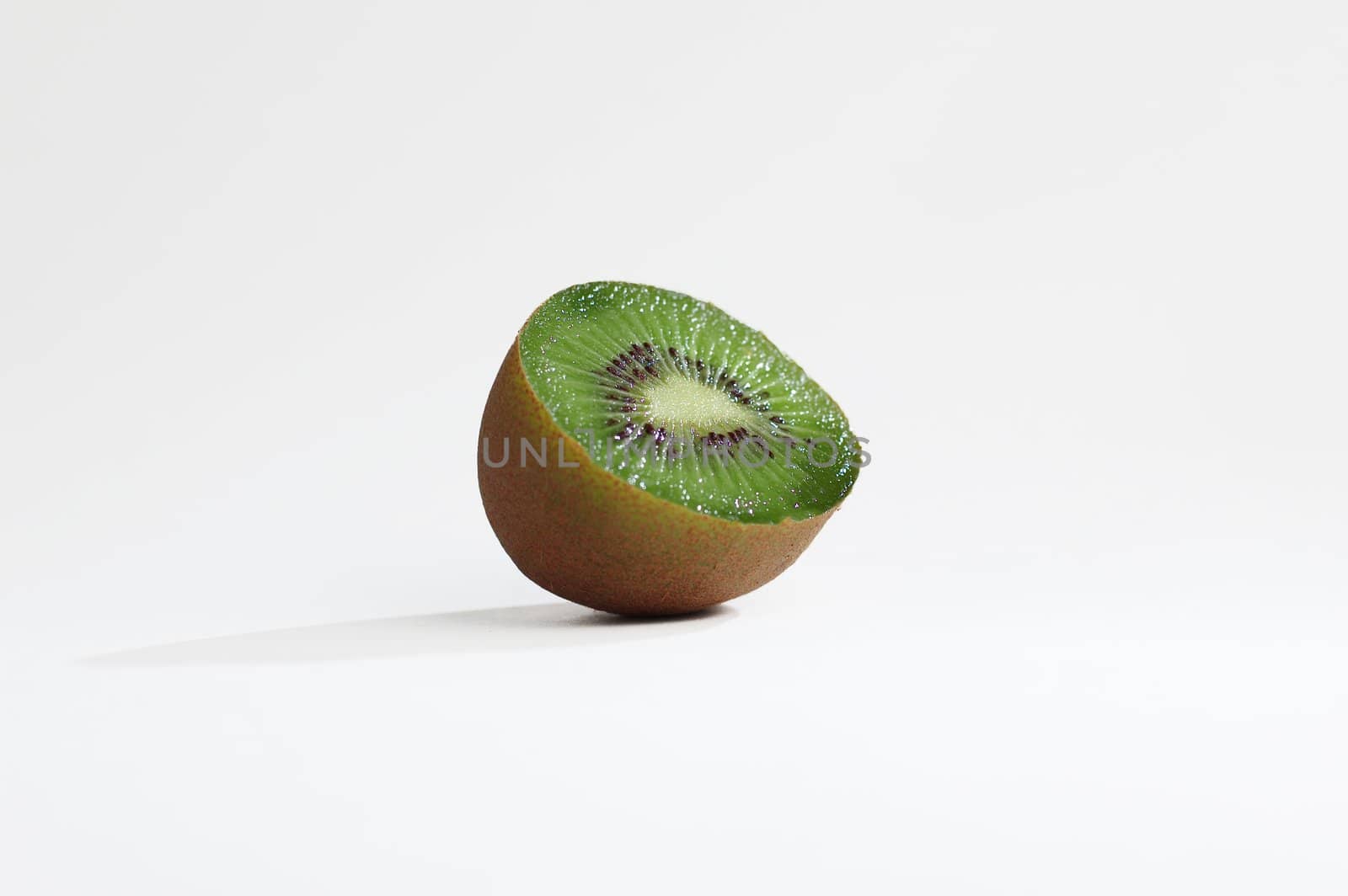 Hunk of sliced kiwi against white background.
