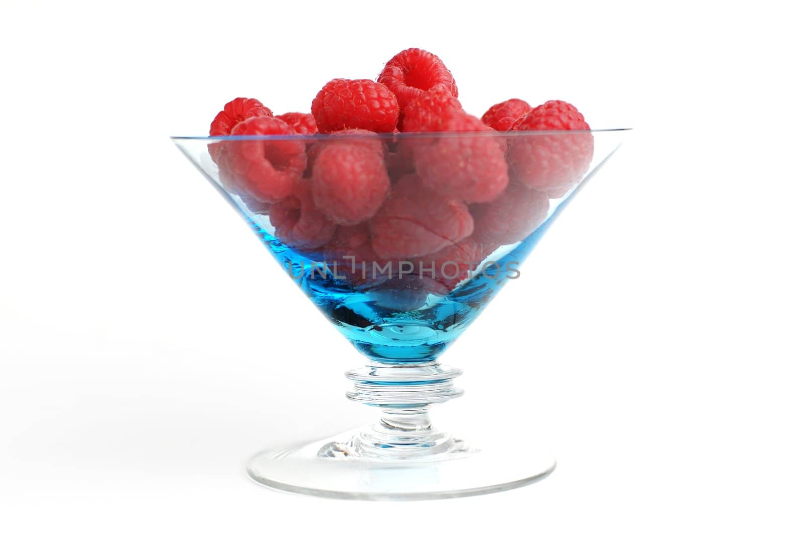 Raspberries in dessert bowl against white background.