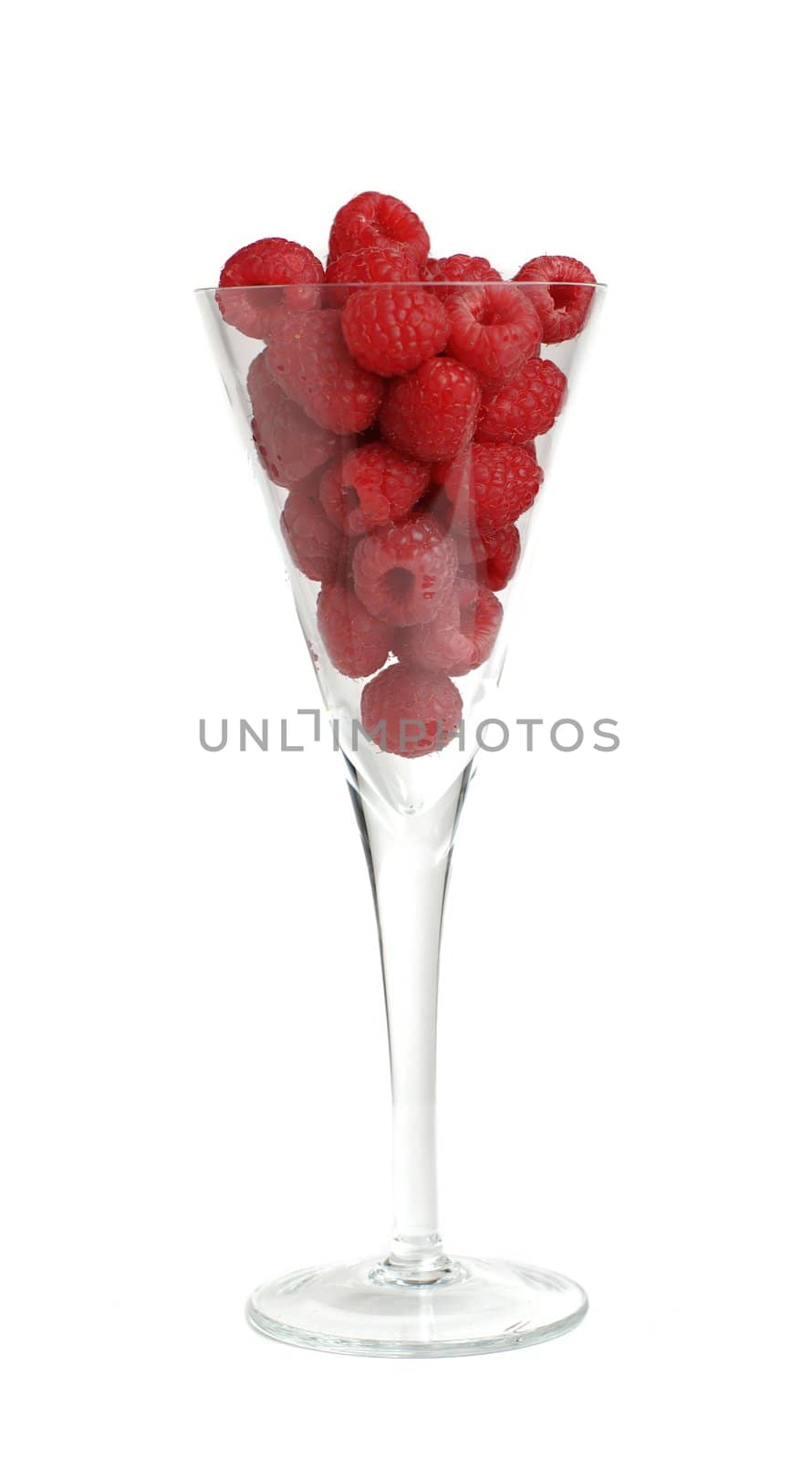 Raspberries in long stem glass against white background.