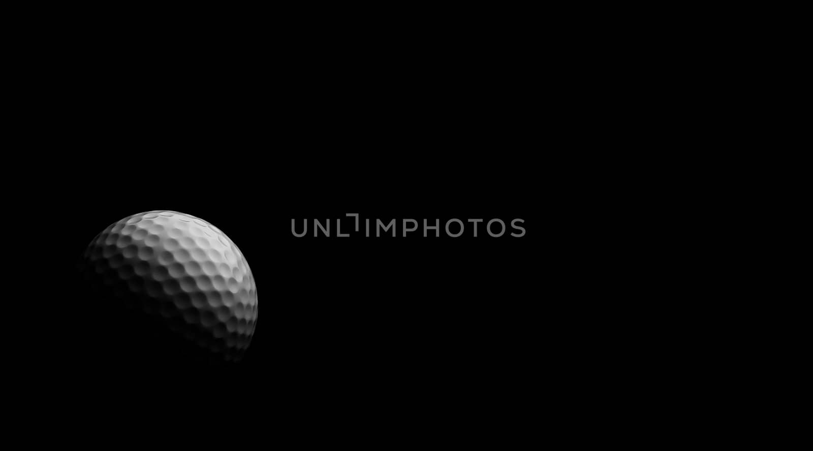 Golf ball under dramatic light, against black.