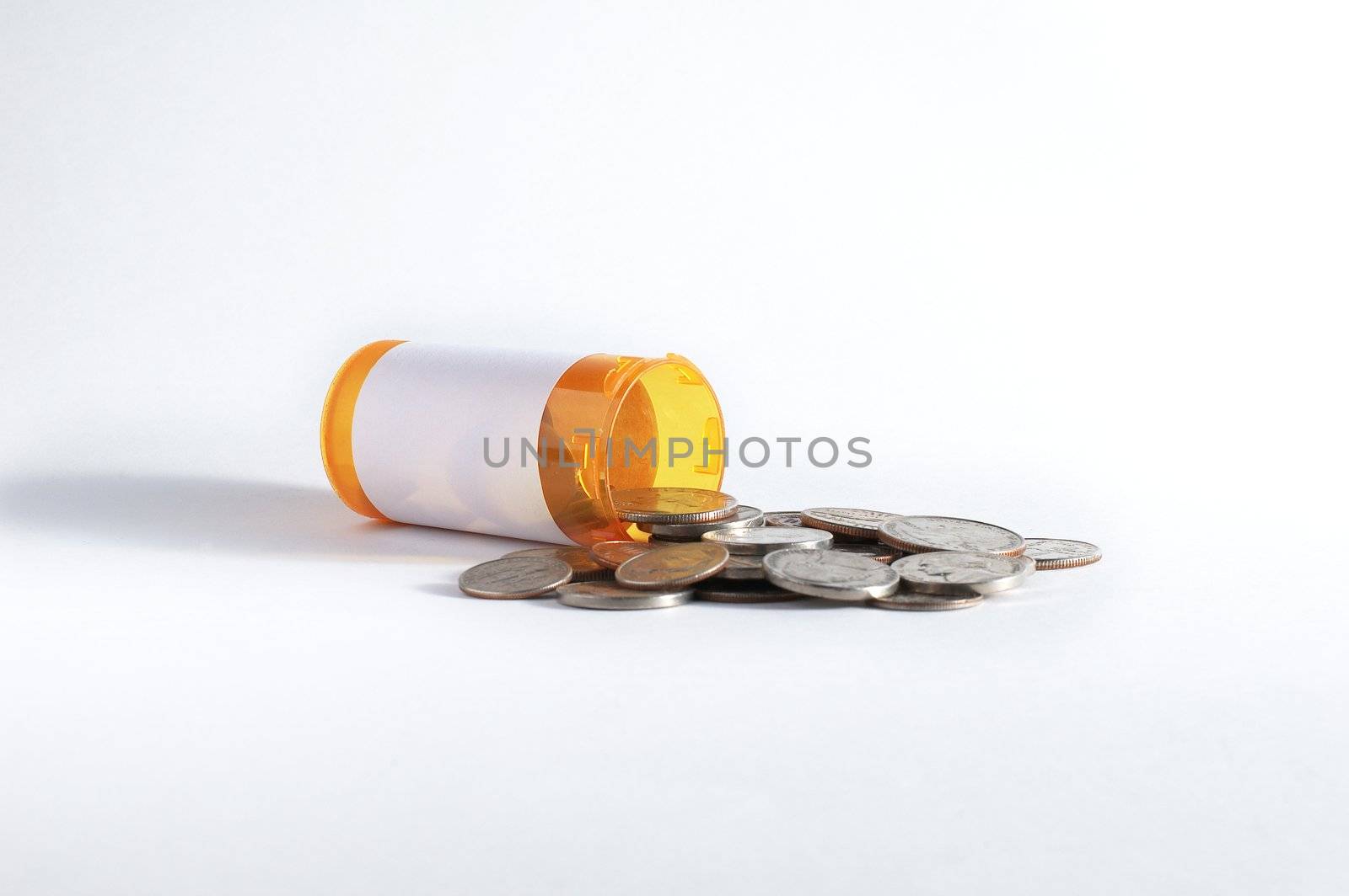 Coins spilling from RX bottle against white background.