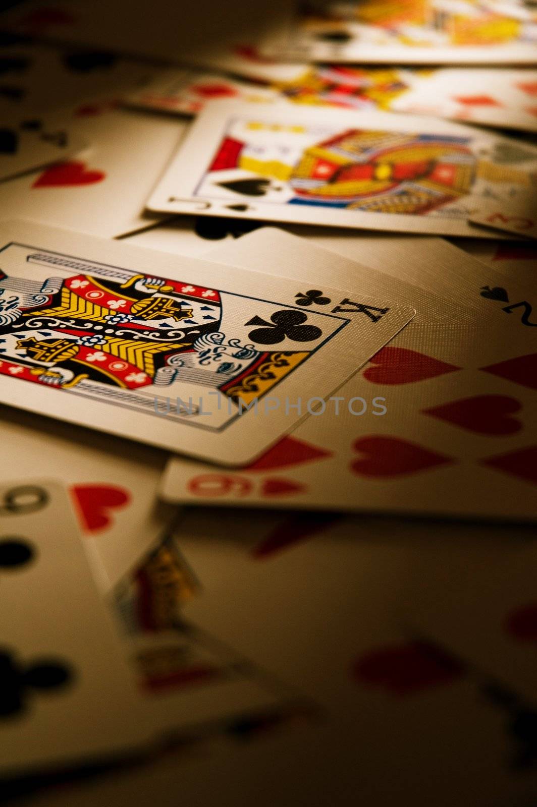 Playing cards on table in dramatic light.