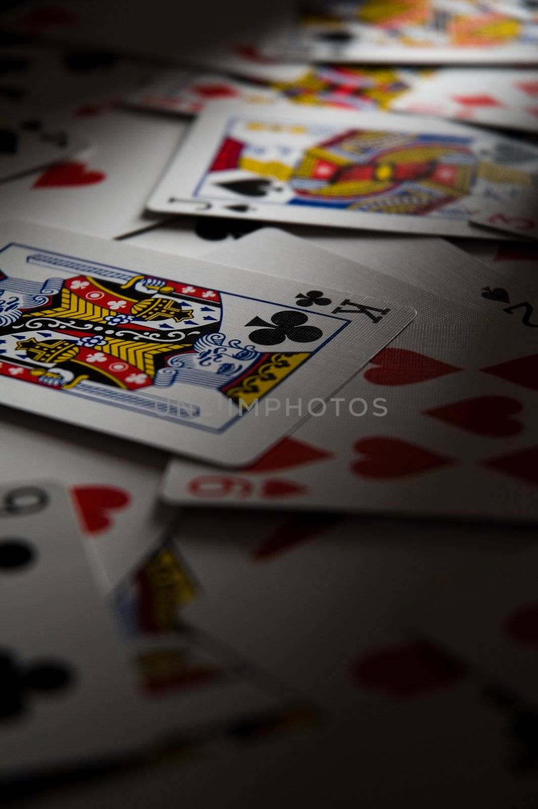 Playing cards on table in dramatic light.