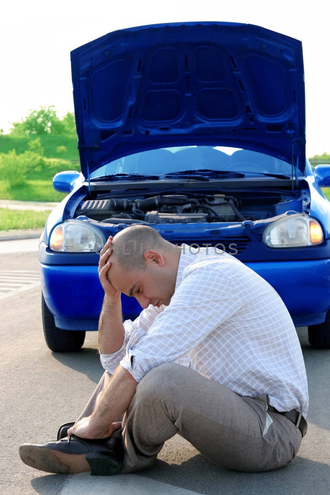 Businessman his hand on his head beside defected a car