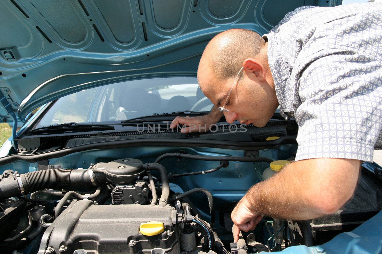 Businessman opening the trunk and checking the engine of a car