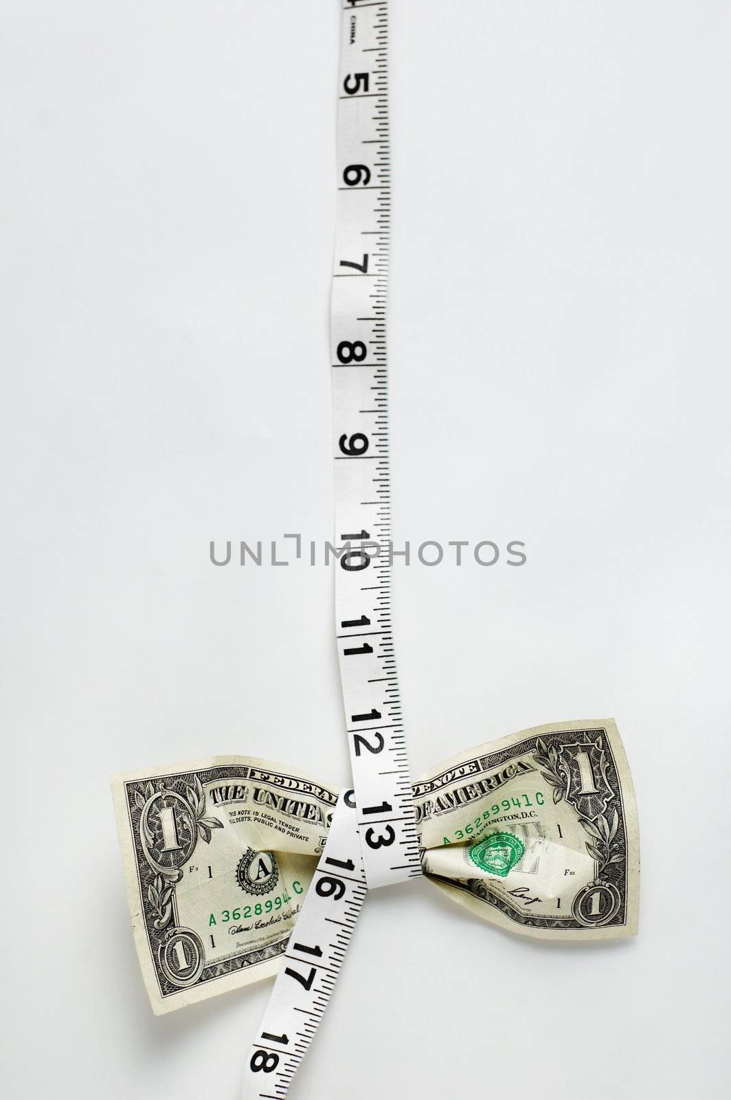 Dollar being squeezed by a tape measurer.