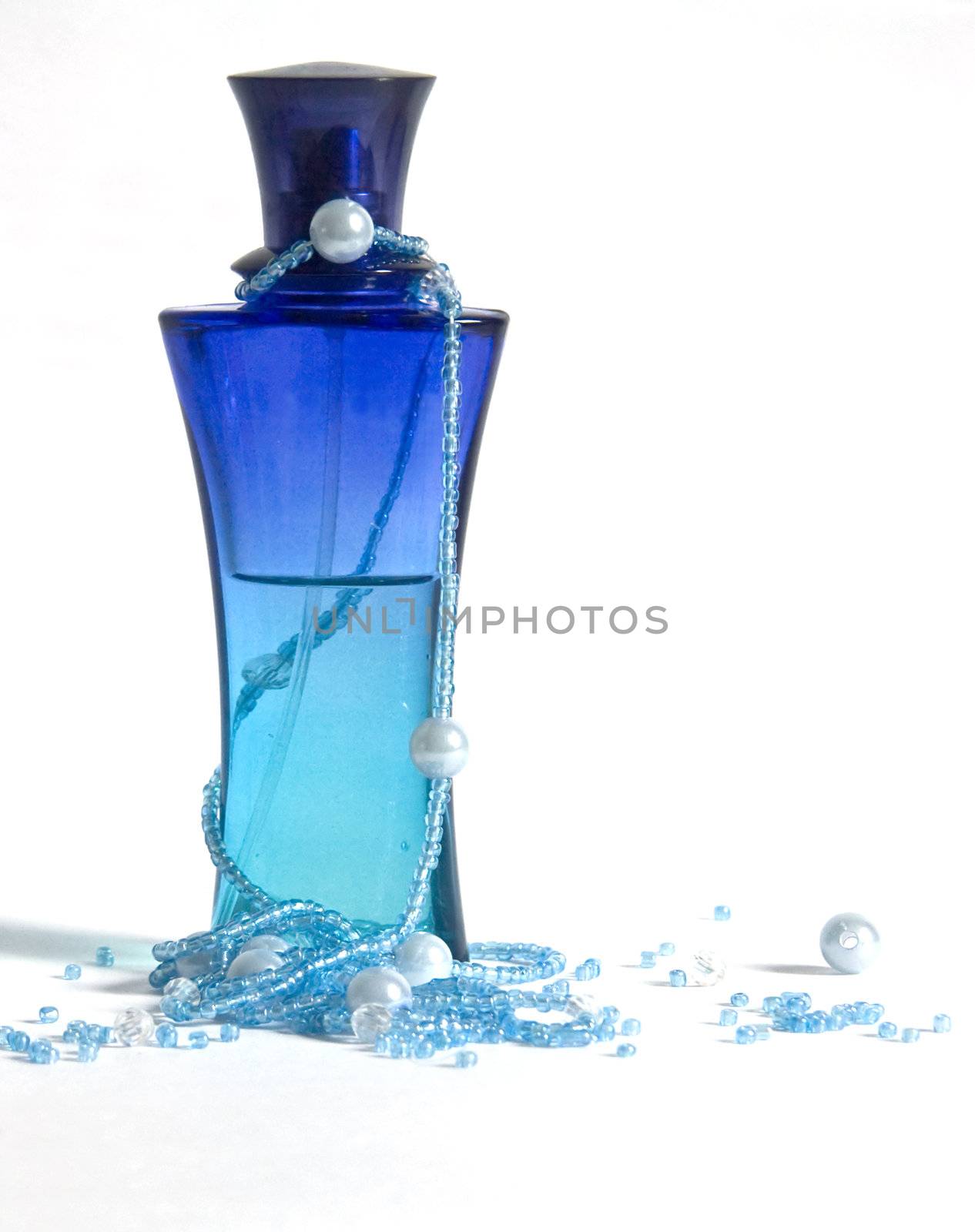 The image of a bottle with perfumery water and the scattered thread of a beads