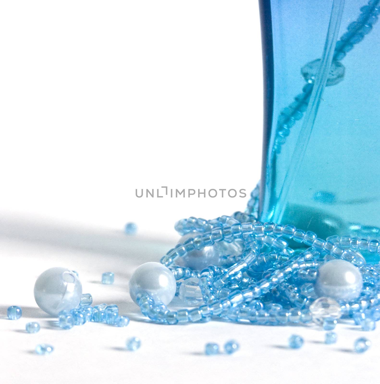 The image of a bottle with perfumery water and the scattered thread of a beads