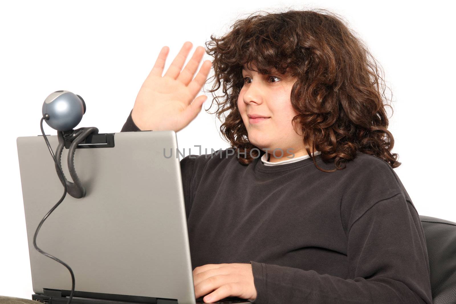 boy using laptop, waving hand of a webcam