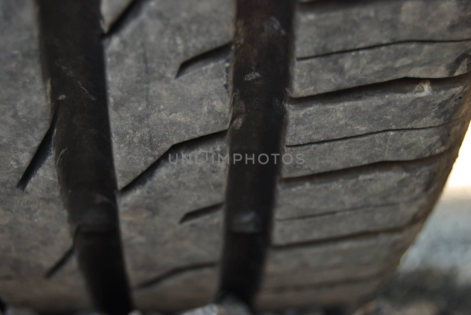 closeup of a car tire profile (car parked on pebbles)