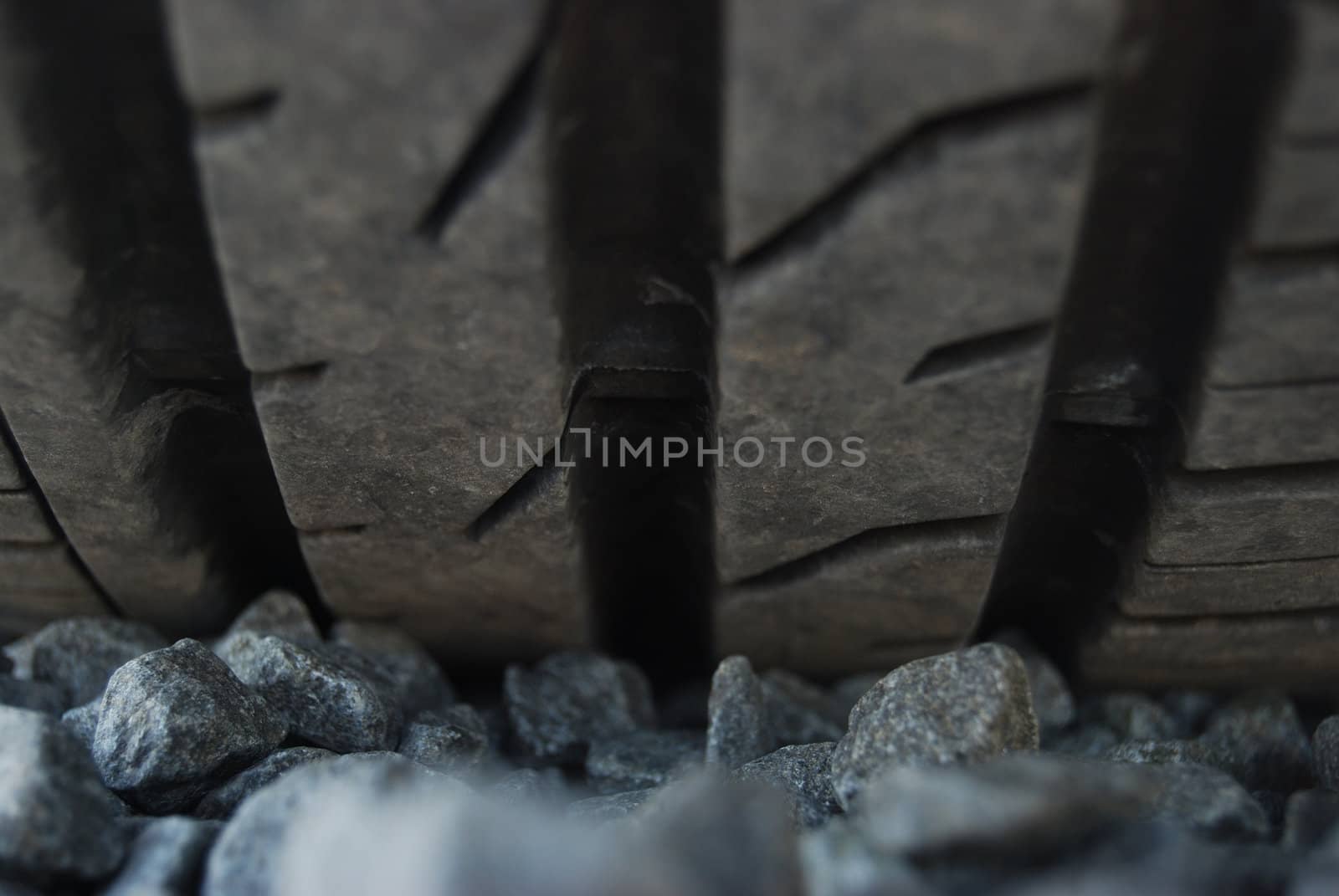 closeup of a car tire profile (car parked on pebbles)