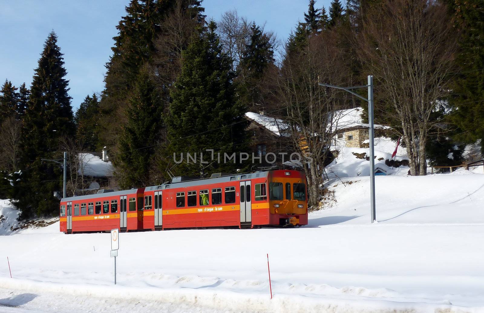 Red small train in Jura mountain by winter time