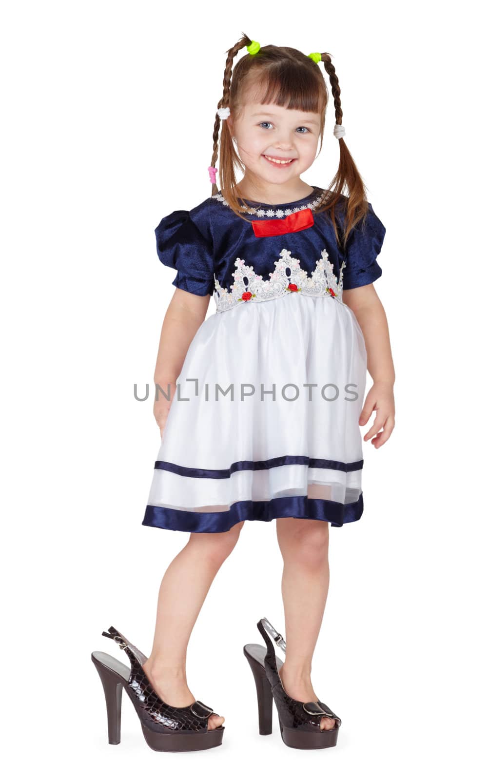 Funny little girl in her mother's big shoes isolated on white background