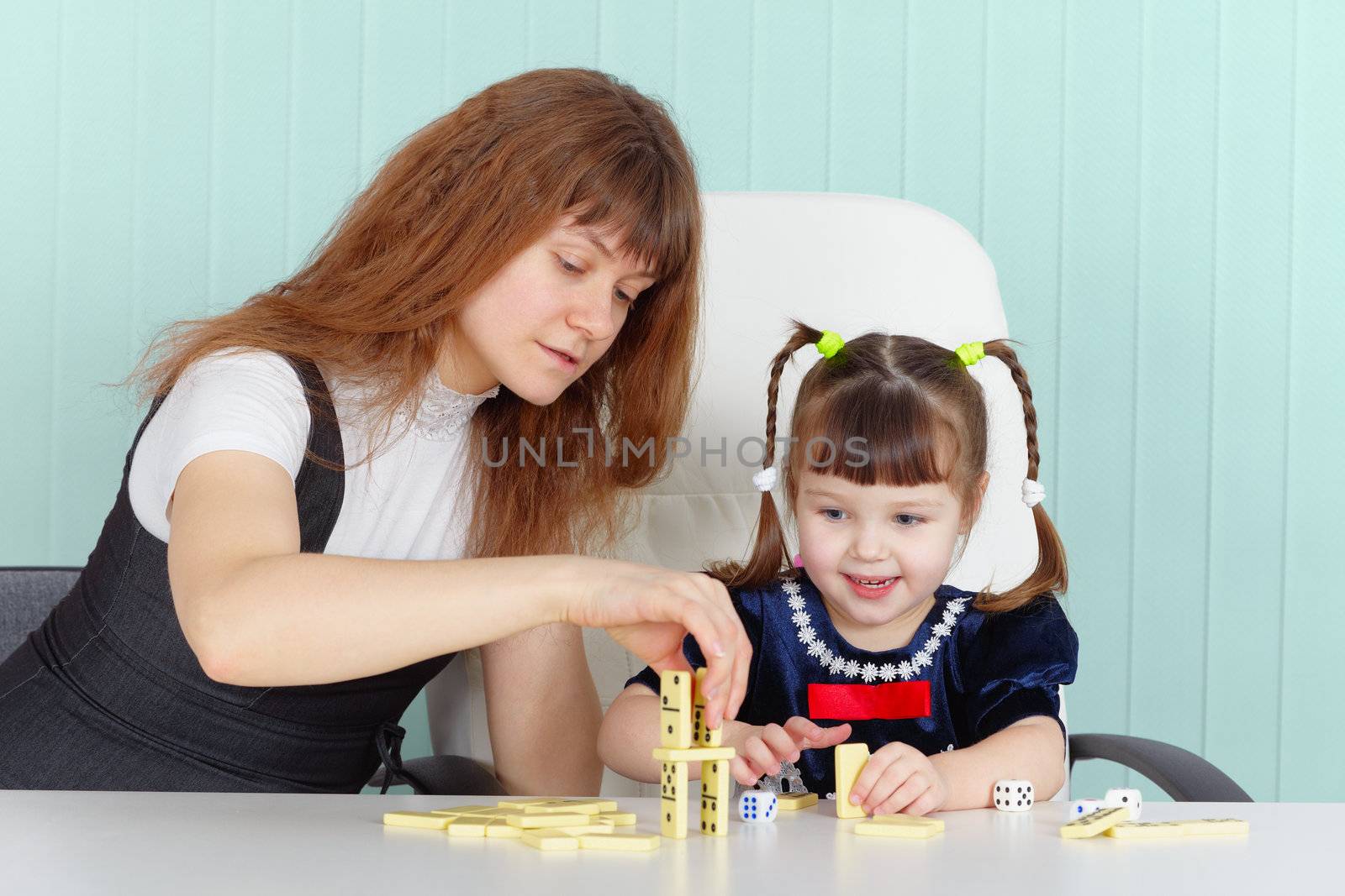 Mother and daughter play together at the table