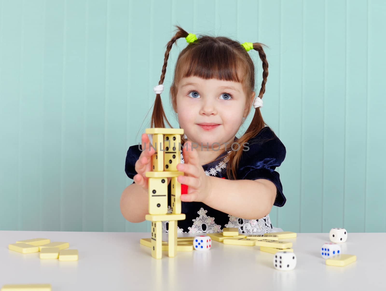 A child playing with small toys, sitting at the table